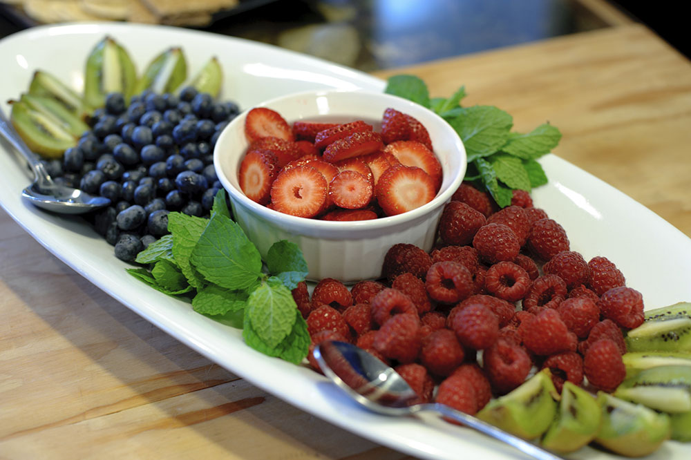 a plate full of strawberries, kiwies and blueberries