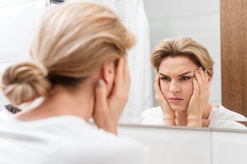 woman looking herself in mirror